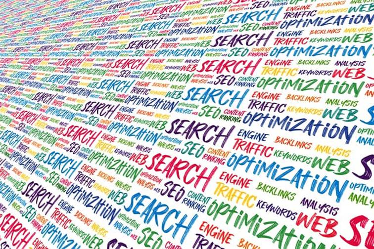 Barevná koláž anglických slov SEO, SEARCH, OPTIMIZATION a TRAFFIC v perspektivě symbolizující výzkum klíčových slov